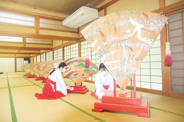 檜扇の台座を巫女が拭き上げた