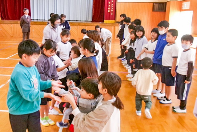 タッチで園児と触れ合う児童